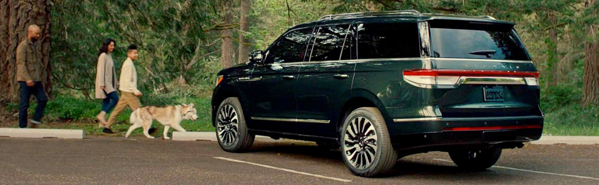 A family and their dog drive home in a 2022 Lincoln Navigator Black Label reflecting on their adventure together in nature