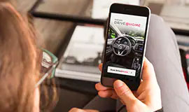 Woman booking a Nissan test drive online on a smartphone