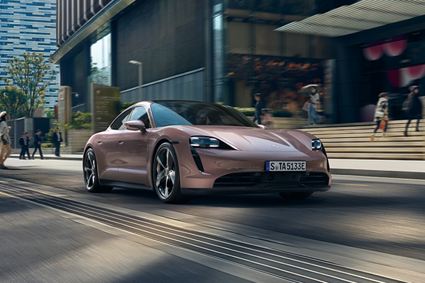 2022 Porsche Taycan driving down a city street during the daytime.