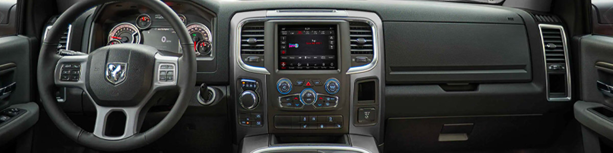 Display The interior of the 2022 Ram 1500 Classic, focusing on the steering wheel, Uconnect touchscreen and dashboard.