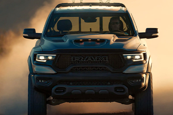 A head-on view of the 2022 Ram TRX with a dust cloud obscuring the background.