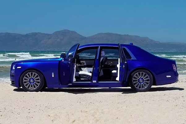 Side shot of a 2022 Rolls-Royce Phantom with the driver and back doors open.
