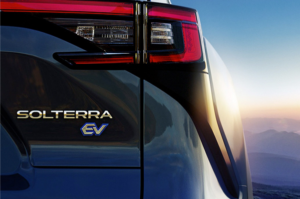 Rear view of Subaru’s all-electric SUV, the Solterra EV, against a blue cloudy sky.
