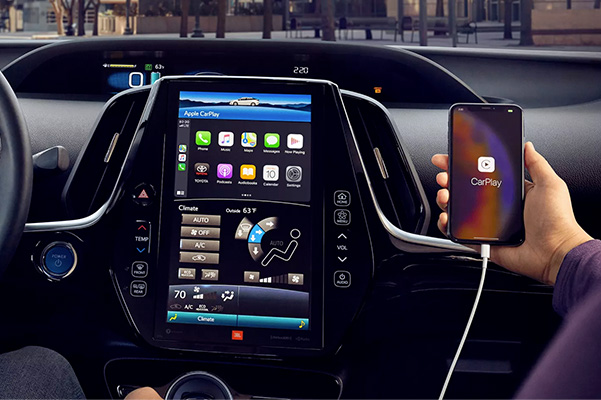 Limited interior shown. Person holding their iPhone showing Apple CarPlay® compatibility
