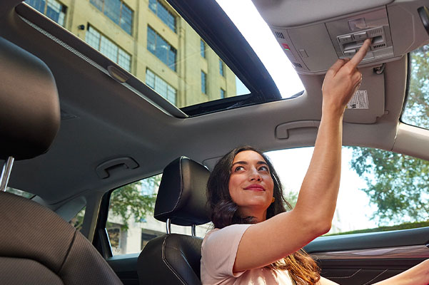 Available panoramic sunroof in use by a person seated in the driver seat in a 2022 Volkswagen Jetta