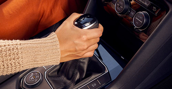 A woman’s hand on the gear shifter of a Taos.