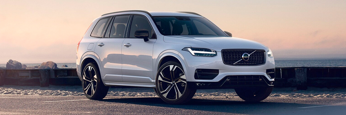 Front side view of XC90 parked on open road at sunset.