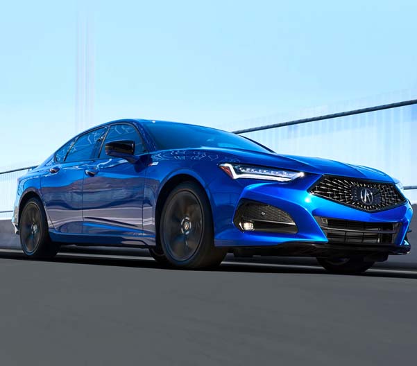 Exterior shot of a 2023 Acura TLX driving on a sunny day.