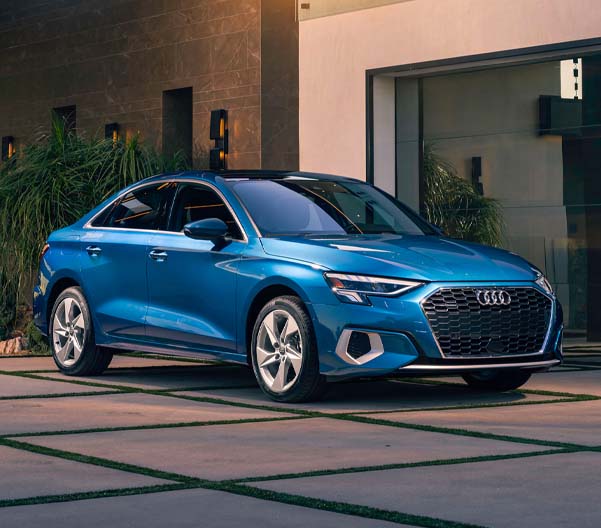 Exterior shot of a blue 2023 Audi A3 parked in a driveway.