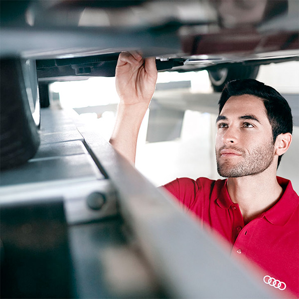 Audi technician checking the underside of an Audi car