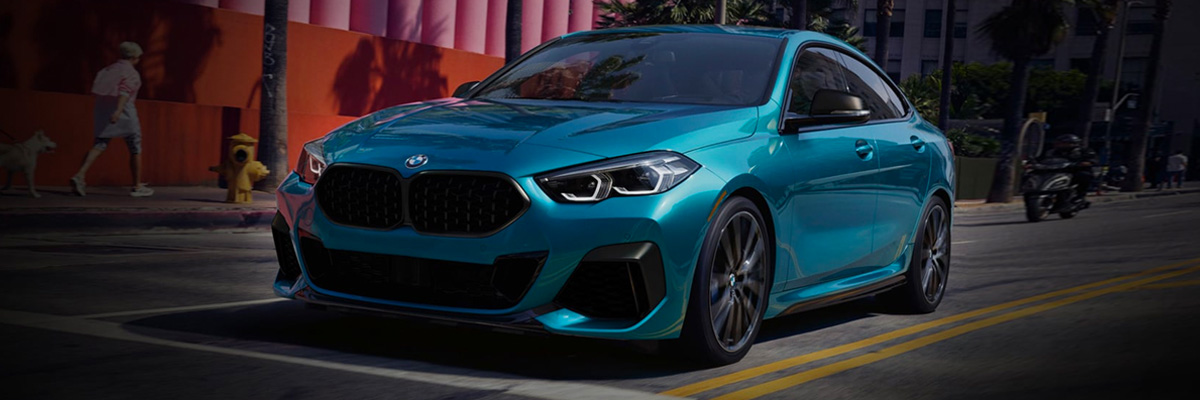 Exterior shot of a 2023 BMW 2 Series driving down a city street.