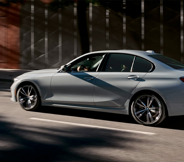 The 2023 BMW 3 Series from the side driving on the highway