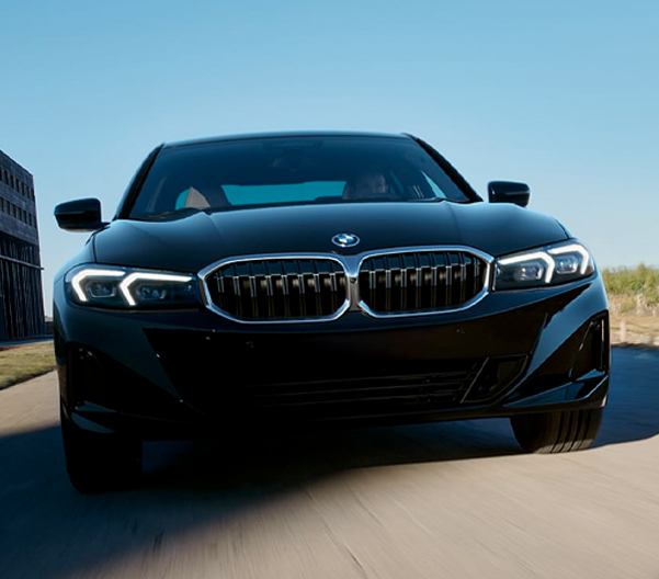Front view of the The 2023 BMW 3 Series driving on a side street
