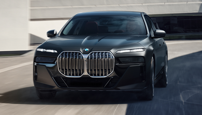 BMW 7 Series Car driving down a road next to wall