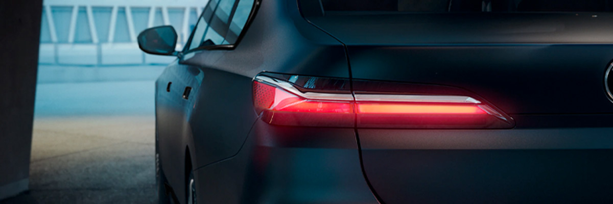 Rear view of the 2023 BMW 7 Series with the headlights on