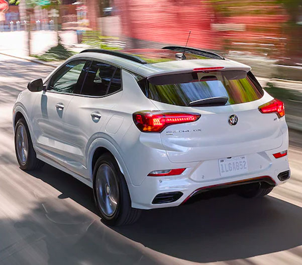 Rear view image of the 2023 Buick Encore GX driving along an urban road