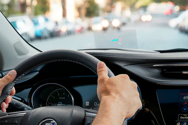 Interior View of man Driving the 2023 Buick Encore GX showing the available Head-Up Display (HUD).