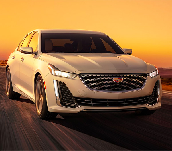 2023 Summit White Cadillac CT5 Fiercely Driving During a Golden Sunset