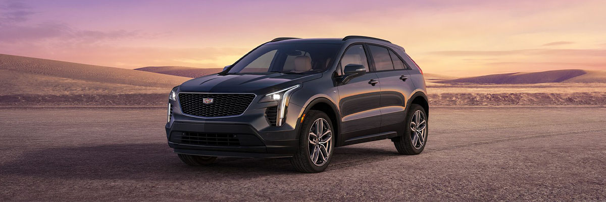 2023 Cadillac XT4 parked with hills in the background during a sunset