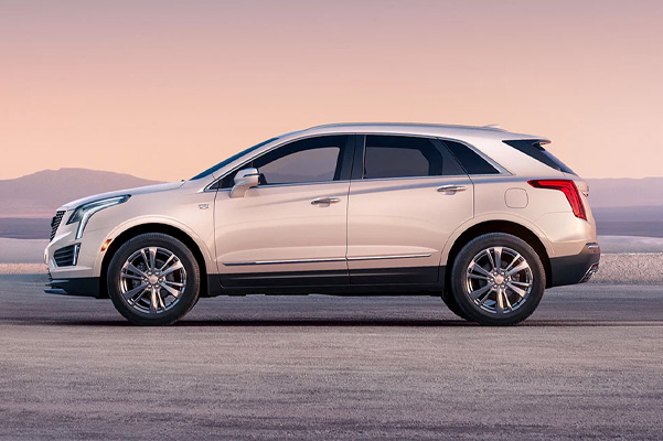 Side view of the 2023 Cadillac XT5 parked in front of mountains