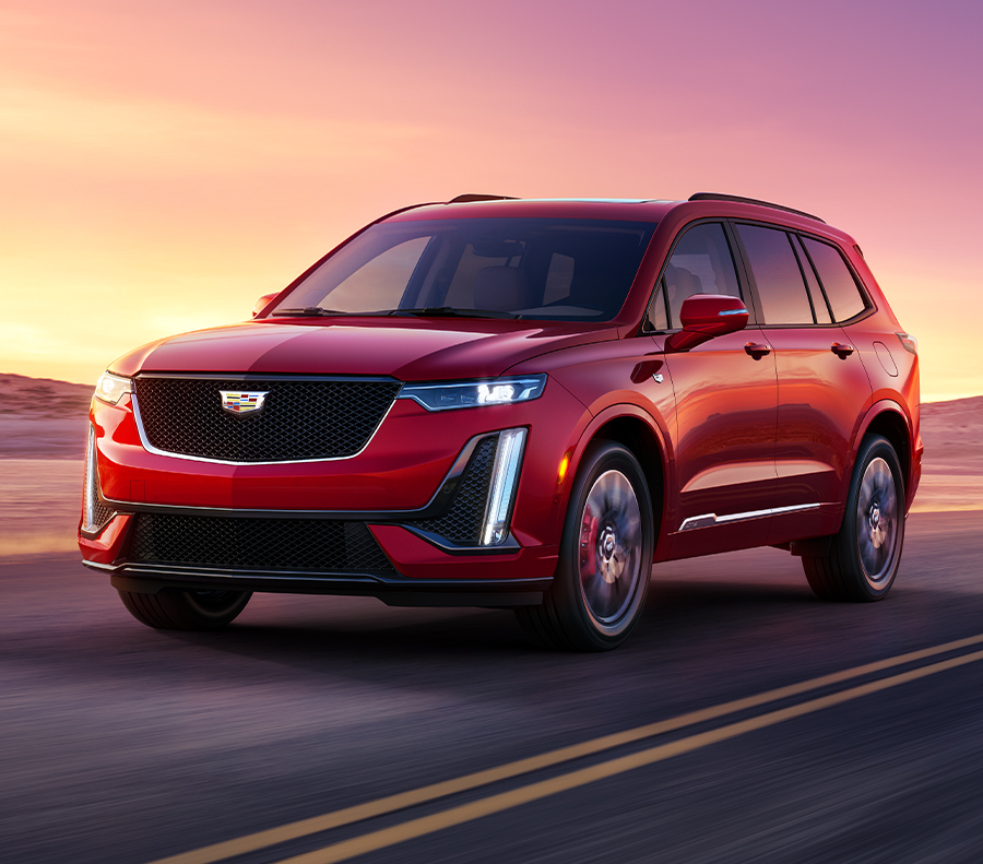 The 2023 Cadillac XT6 driving on road with mountains in the background