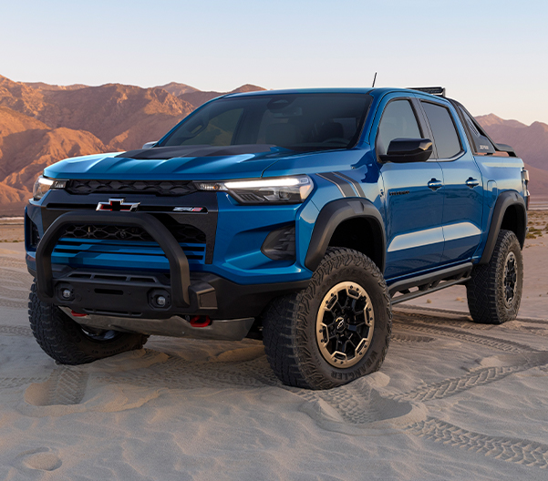 The 2023 Bright Blue Metallic Chevy Colorado Parked in the Sand with a View of the Mountains