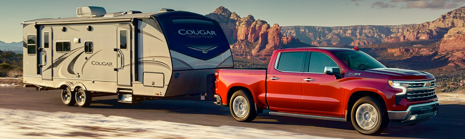 The Red Hot 2023 Silverado Towing an RV on a Desert Roadway