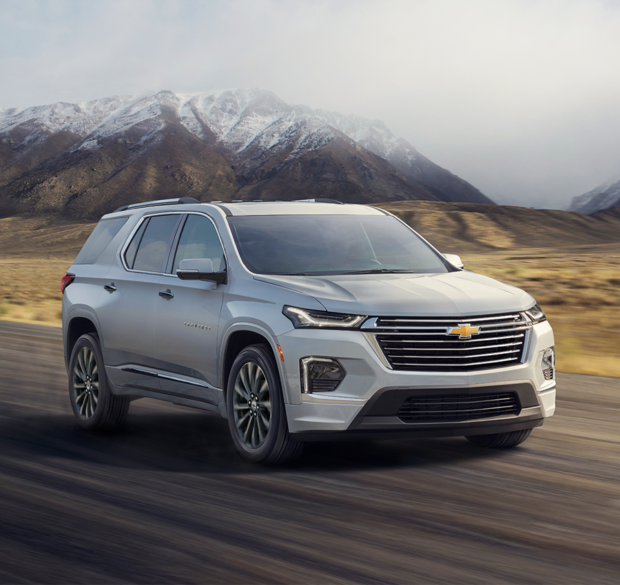 Chevy Traverse Driving Down Road with Beautiful Mountains in Background