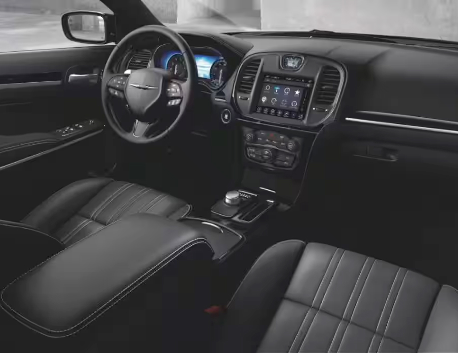 Display The interior of the 2023 Chrysler 300 focusing on the front seats, steering wheel, touchscreen and dashboard.