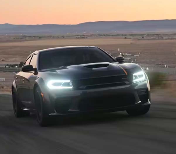 Image of the 2023 Dodge Charger racing along a rural highway