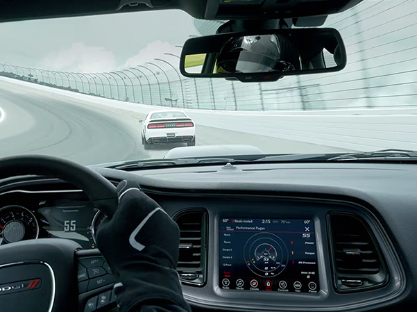 The interior of a 2023 Dodge Challenger and the Uconnect touchscreen displaying a Dodge Performance Page.