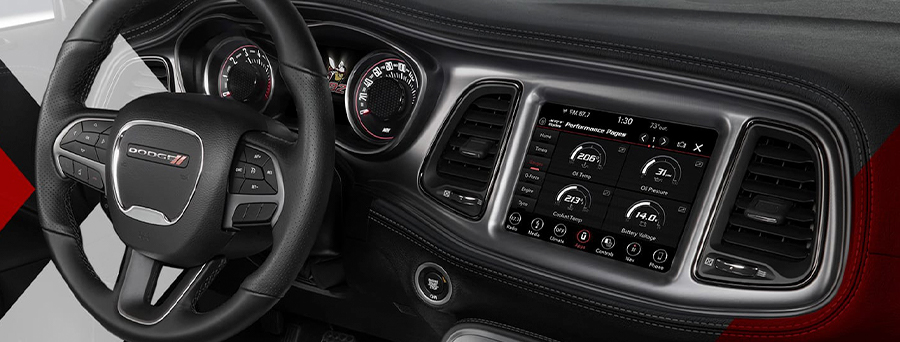 The interior of the 2023 Dodge Challenger focusing on the steering wheel, Digital Cluster and Uconnect touchscreen.