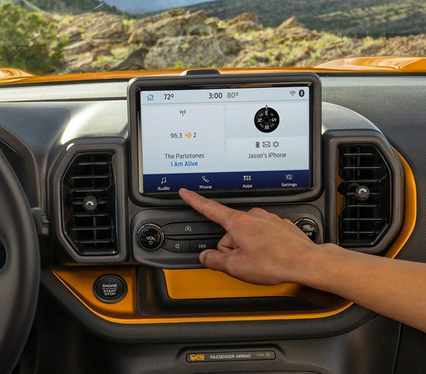 Two people using the eight inch touchscreen in a 2023 Ford Bronco® Sport SUV