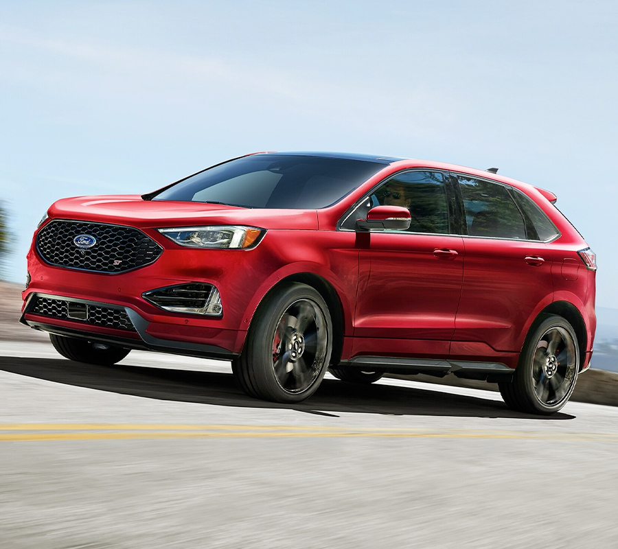 2023 Ford Edge® SUV being driven on a mountain road with city in background