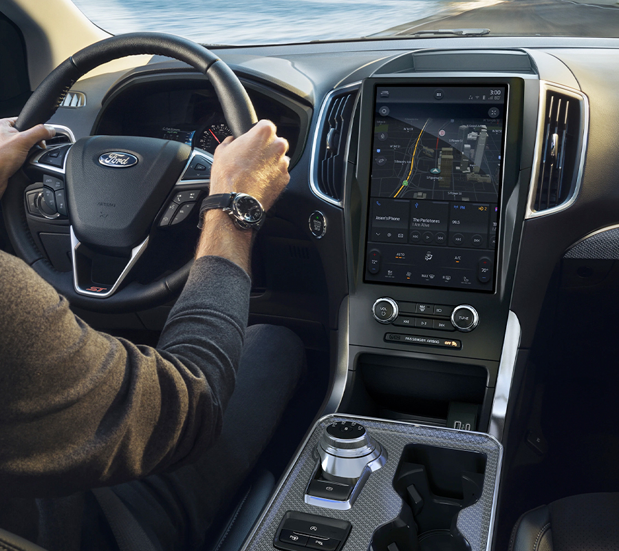 Interior of a 2023 Ford Edge® as a man drives and looks at interior console