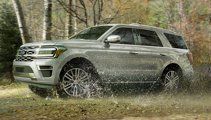 A 2023 Ford Expedition SUV being driven through wet grass