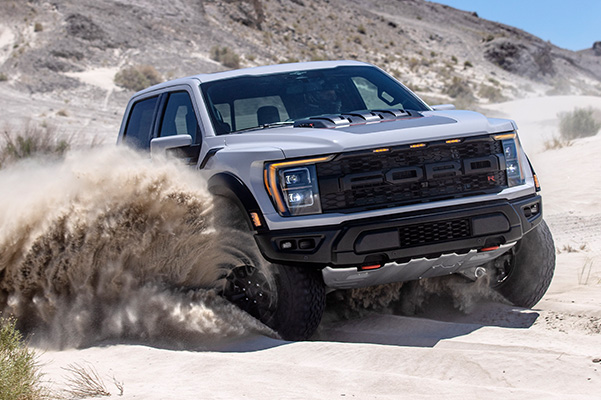 2023 Ford F-150 Raptor kicking up sand in the dunes.
