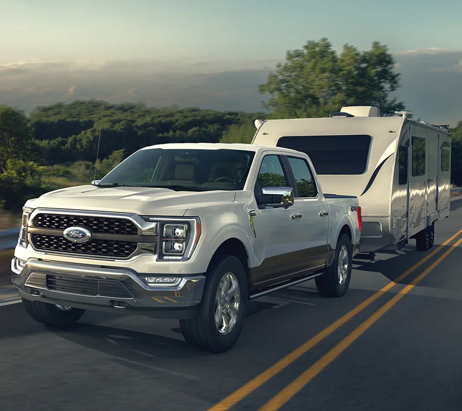 Powerful 2023 Ford F-150 towing a camper up a hill