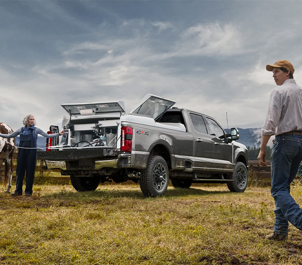 Man walking with a horse toward two women standing at the rear of a 2023 Ford Super Duty® F-250® Platinum pickup
