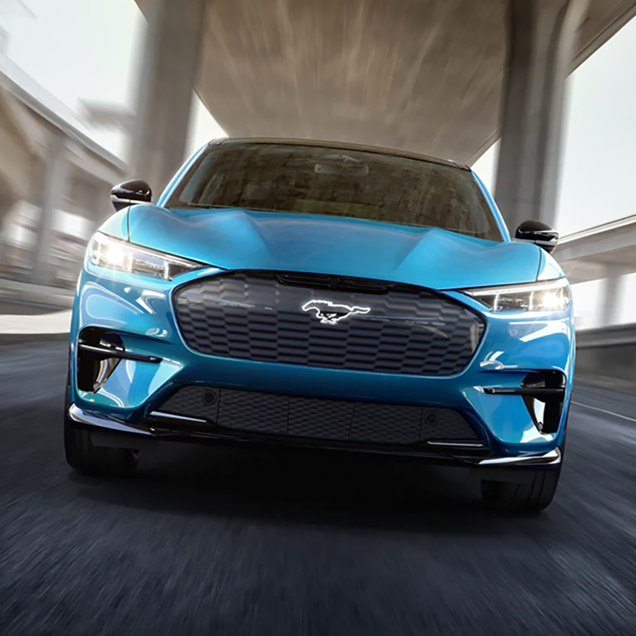 Front-end of a 2023 Ford Mustang Mach-EĀ® Performance Edition against a blurry freeway in the background