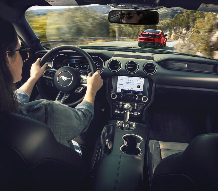 Interior view of woman driving Ford Mustang