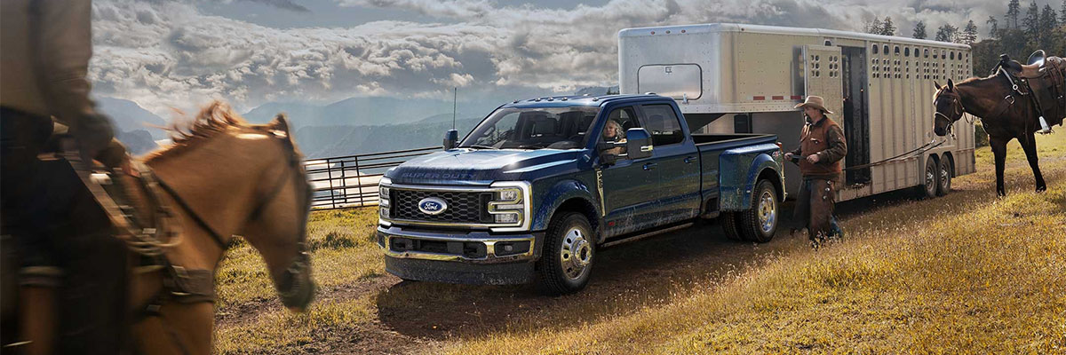 2023 Ford Super Duty parked along a road with horses