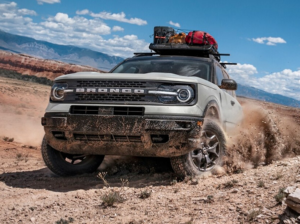 The 2023 Ford Bronco Sport driving on a dirt road kicking up dust