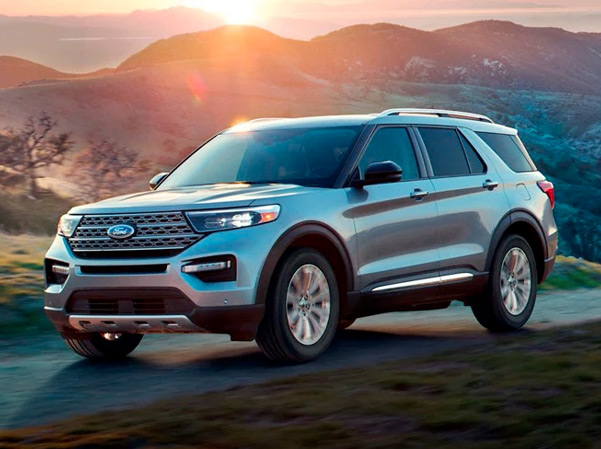 The 2023 Ford Explorer driving on a road with mountains in the background
