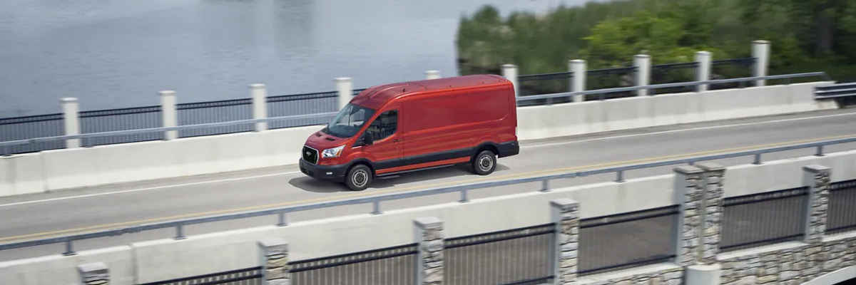 Ford Transit in Race Red being driven across a bridge