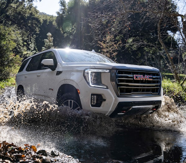 2023 GMC Yukon AT4 Full-Size Off-Road SUV Driving Up Dirt Hill