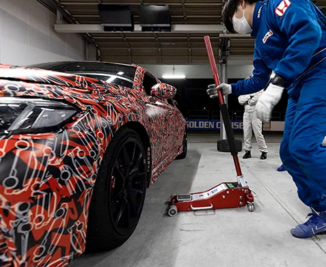 2022 Honda Civic Type R Prototype shown. Person with wheel jack