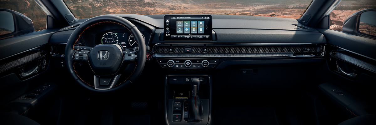 An interior shot of the 2023 Honda CR-V, showing the steering wheel and center console