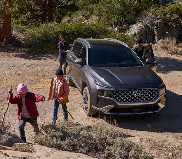 2023 Santa Fe Hybrid pictured in background family in foreground