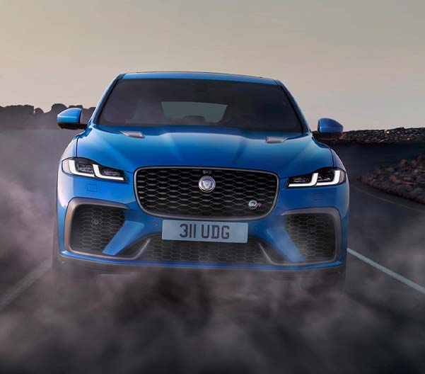 Exterior shot of a 2023 Jaguar F-PACE driving on a dusty road.